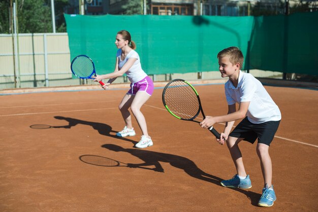 Frau und Kind, die Tennis spielen