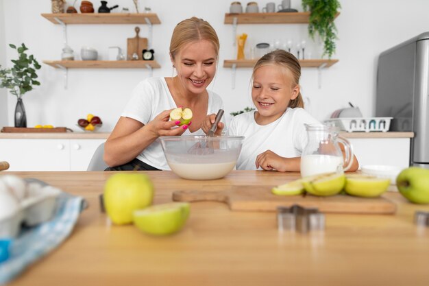 Frau und Kind kochen mit mittlerer Aufnahme