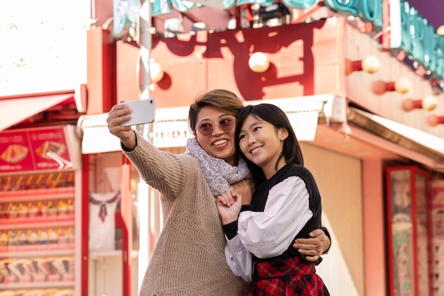 Frau und Mädchen mit mittlerer Aufnahme, die ein Selfie machen