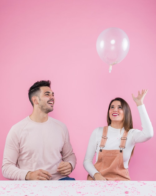 Frau und Mann, die mit Luftballon spielen