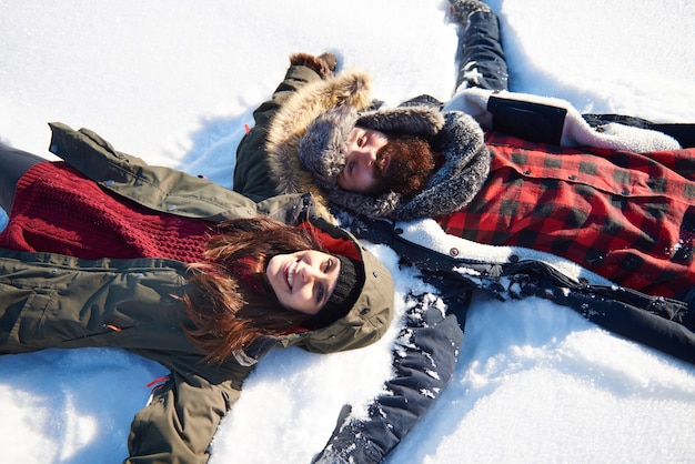 Frau und Mann machen Schneeengel