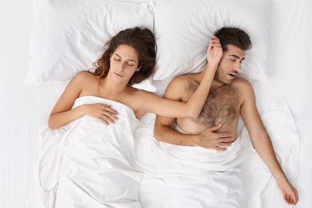 Frau und Mann sitzen in der Draufsicht des Bettes