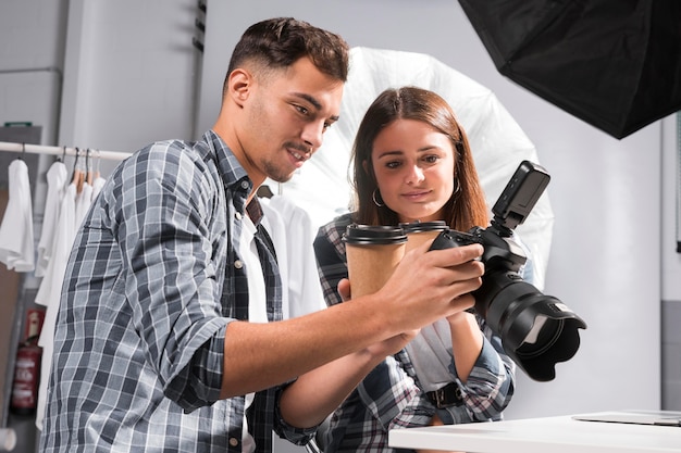 Frau und Mann suchen vor der Kamera nach Fotos