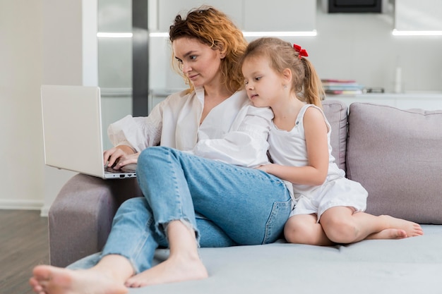 Frau und Tochter sitzen auf der Couch