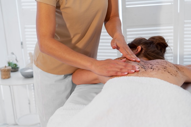 Frau verbringt Zeit im Spa und bekommt eine Peeling-Massage