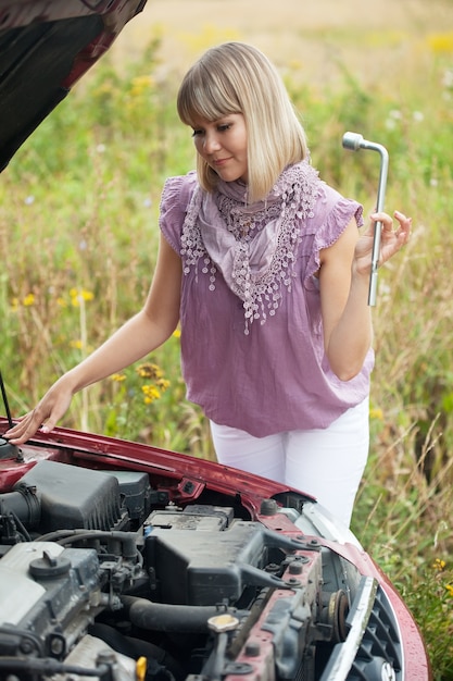 Frau versucht, das Auto zu reparieren