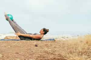 Kostenloses Foto frau während der harten yoga-sitzung im freien