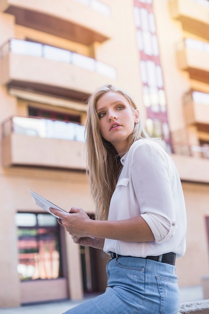 Frau, welche die digitale Tablette weg schaut hält