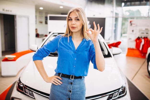 Frau, welche die gefühle stehen vor einem auto zeigt