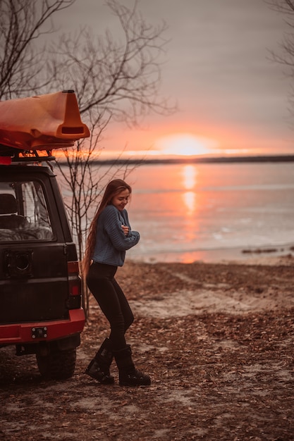 Frau, welche die Zeit sich entspannt durch den schönen See bei Sonnenaufgang genießt