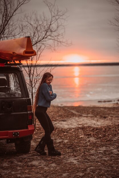 Frau, welche die Zeit sich entspannt durch den schönen See bei Sonnenaufgang genießt
