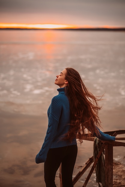 Frau, welche die Zeit sich entspannt durch den schönen See bei Sonnenaufgang genießt