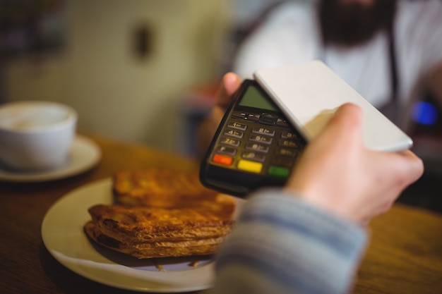 Frau zahlen Rechnung durch Smartphone NFC-Technologie