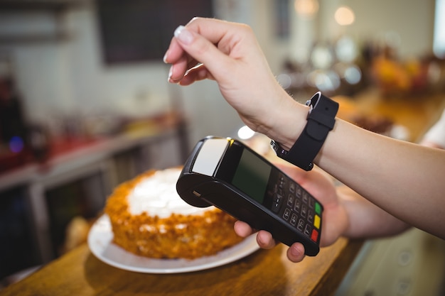 Frau zahlen Rechnung durch Smartwatch mit NFC-Technologie