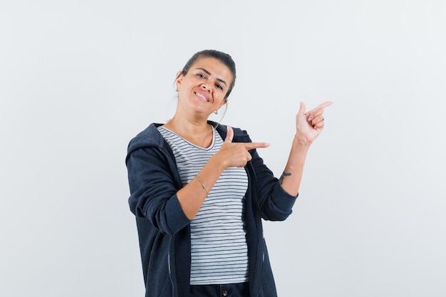 Frau zeigt auf die rechte Seite im T-Shirt