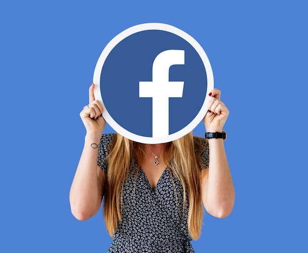 Frau zeigt ein Facebook-Symbol