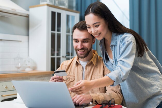 Frau zeigt Mann auf Laptop, was sie online kaufen möchte