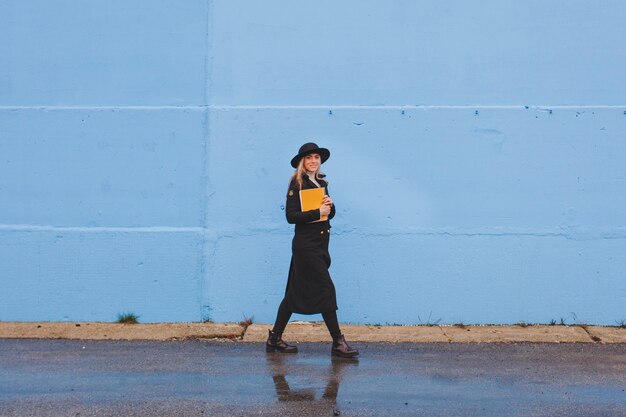 Frau zu Fuß vor der blauen Wand