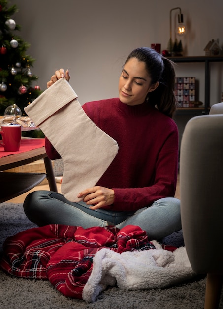 Kostenloses Foto frau zu hause, die riesige socken vorbereitet, damit sankt geschenke lässt