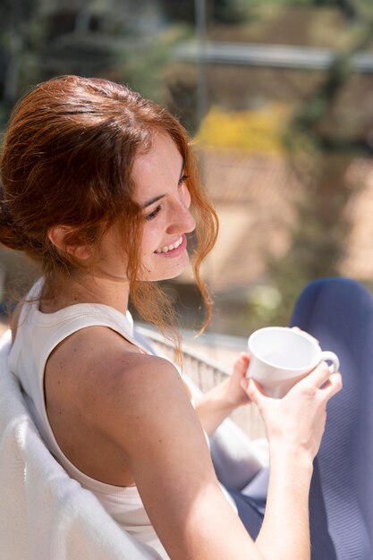 Frau zu Hause, die Tasse Kaffee genießt