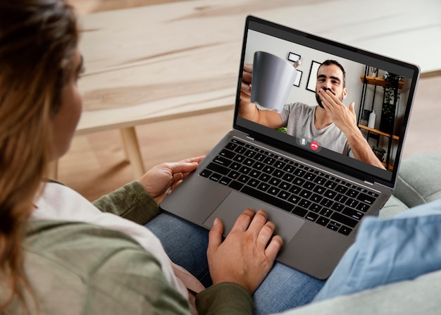 Frau zu Hause, die Videoanruf auf Laptop hat