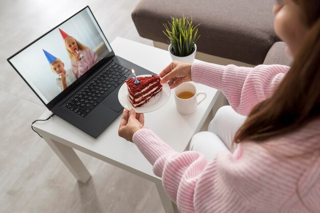 Frau zu Hause in der Quarantäne, die Kuchen mit Freund über Laptop hat