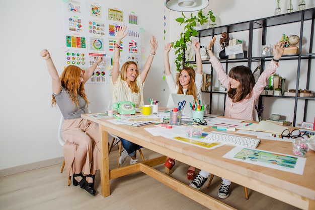 Frauen am Arbeitsplatz mit den Händen hoch