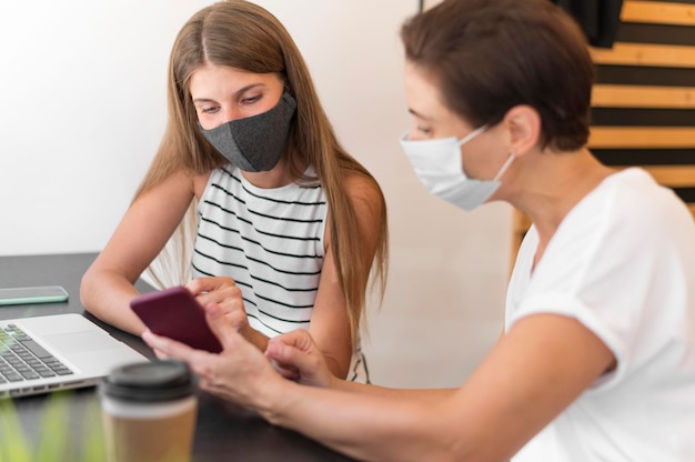 Frauen auf der Terrasse tragen Maske