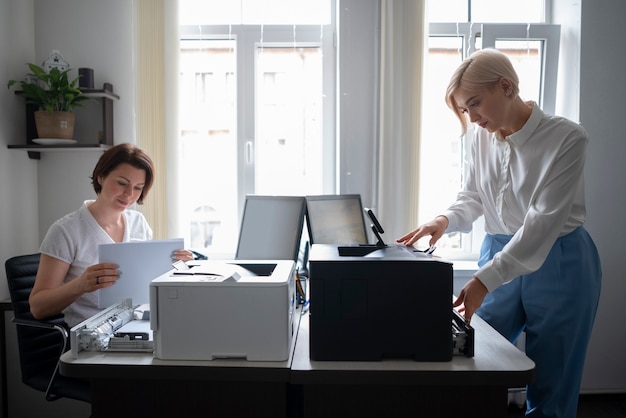 Kostenloses Foto frauen bei der arbeit im büro mit drucker