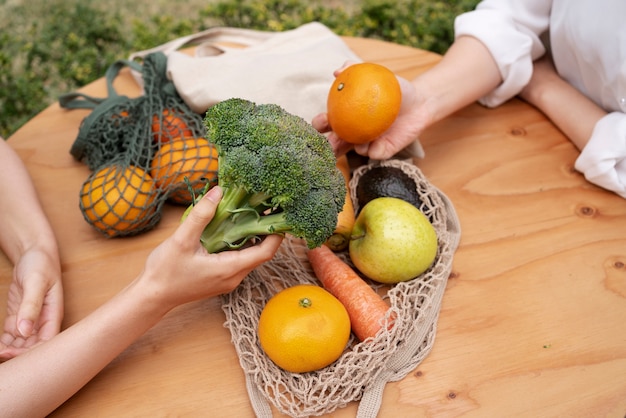 Kostenloses Foto frauen des hohen winkels mit obst und gemüse