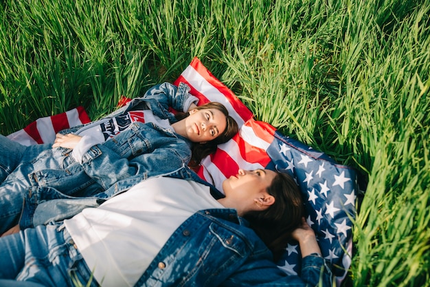 Frauen, die auf amerikanischer Flagge liegen