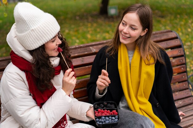 Frauen, die auf Bank sitzen, mittlerer Schuss