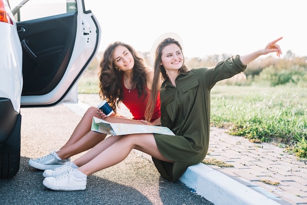 Kostenloses Foto frauen, die auf grenze sitzen und weg schauen