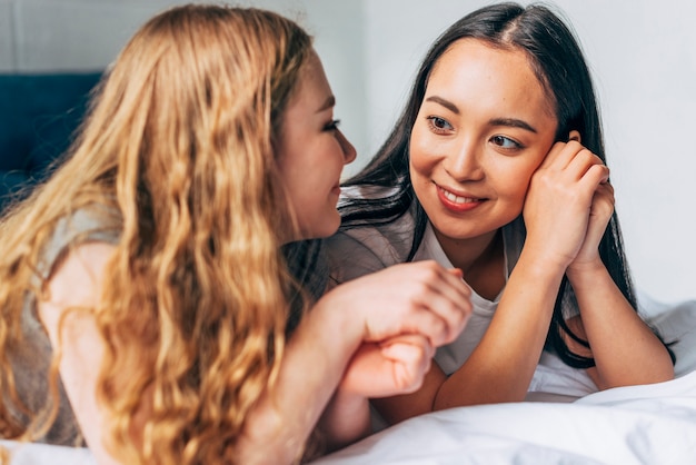 Frauen, die beim Lügen auf Bett plaudern