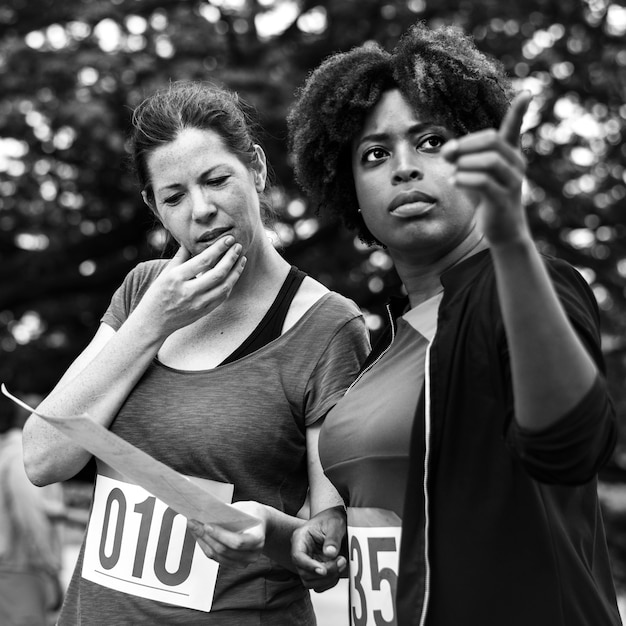 Frauen, die die Karte für Orienteering-Kastenstandort betrachten