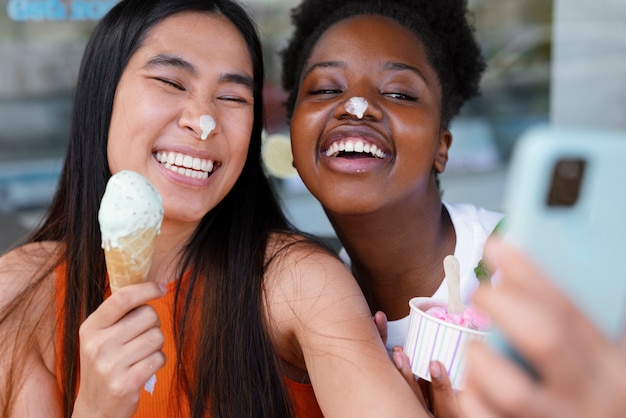 Frauen, die draußen Eis essen