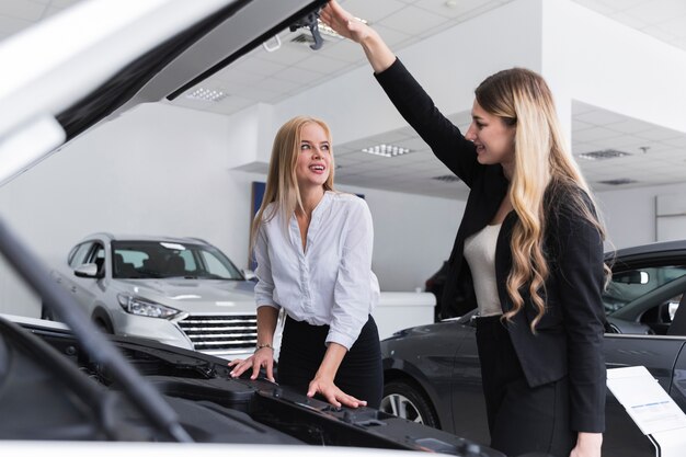 Frauen, die einander mit der Autohaube offen betrachten