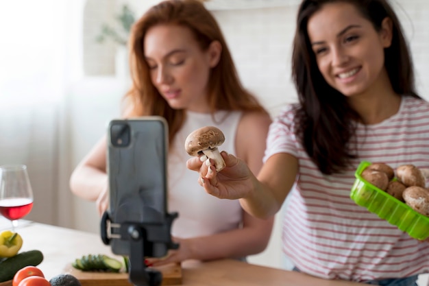 Kostenloses Foto frauen, die einen vlog machen, während sie essen zubereiten