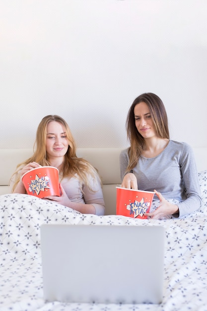 Frauen, die Film im Bett beobachten