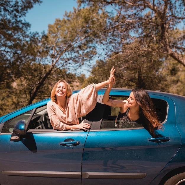 Frauen, die im Auto high-fiving sind