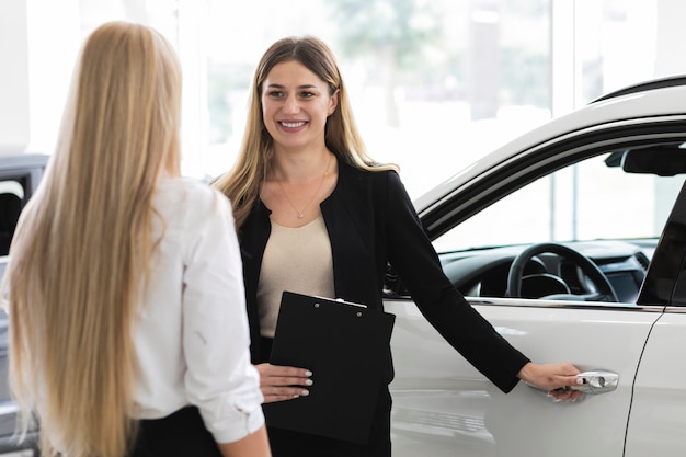 Frauen, die im Autosalon sich besprechen