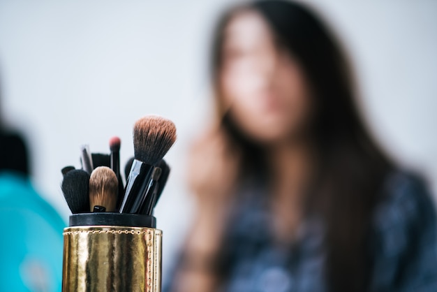 Frauen, die Make-up mit Bürste und Kosmetik tun