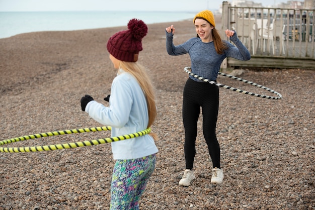 Kostenloses Foto frauen, die mit hula-hoop-kreis trainieren