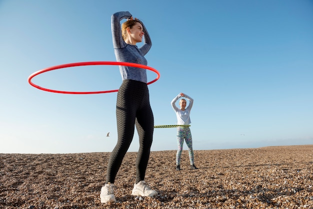 Frauen, die mit Hula-Hoop-Kreis trainieren