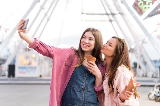 Frauen, die Selfie zusammen im Vergnügungspark nehmen