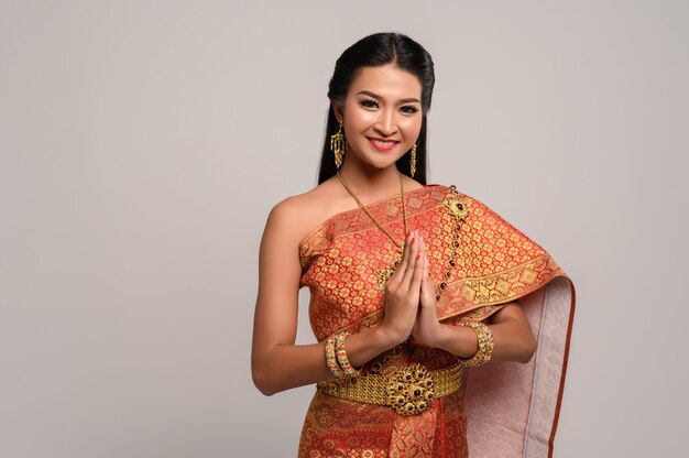 Frauen, die thailändische Kleidung tragen, die Respekt zahlen, sawasdee Symbol