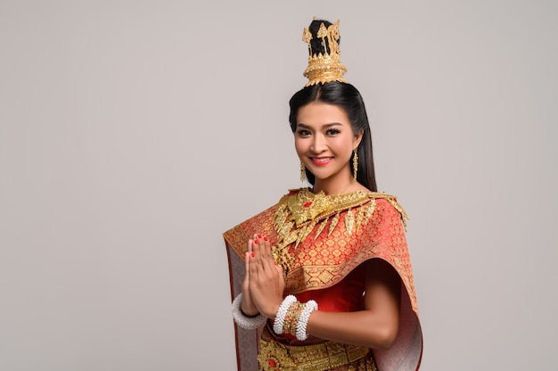 Frauen, die thailändische Kleidung tragen, die Respekt zahlen, sawasdee Symbol