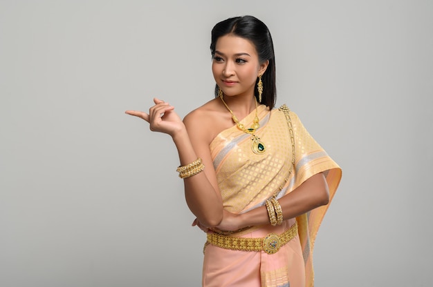 Frauen, die thailändische kostüme tragen, die symbolisch sind und finger zeigen