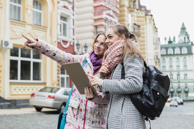 Frauen, die weg zeigen und Tablette verwenden