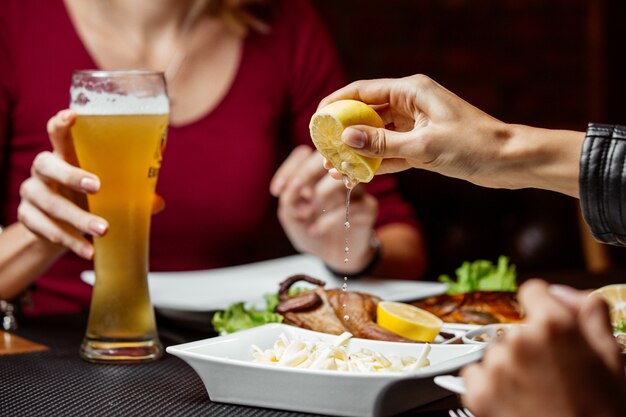 Frauen, die Zitrone auf String-Käse-Bier-Snack drücken